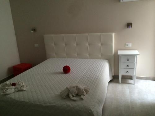 una camera da letto con un letto bianco con due peluche sopra di Appartamento Galante a San Vito lo Capo