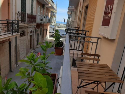 d'un balcon avec des chaises et des plantes dans un bâtiment. dans l'établissement Maison Marguerite, à Margherita di Savoia