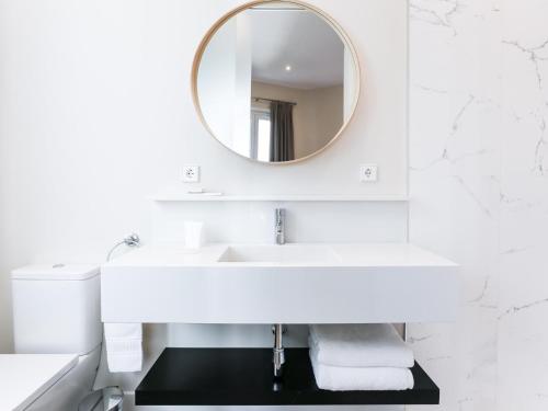 a white bathroom with a sink and a mirror at Mateo Gago ático in Seville