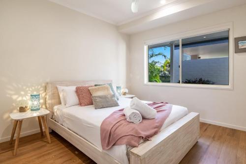 a bedroom with a bed with a window at A Wave From It All - Lennox Head in Lennox Head