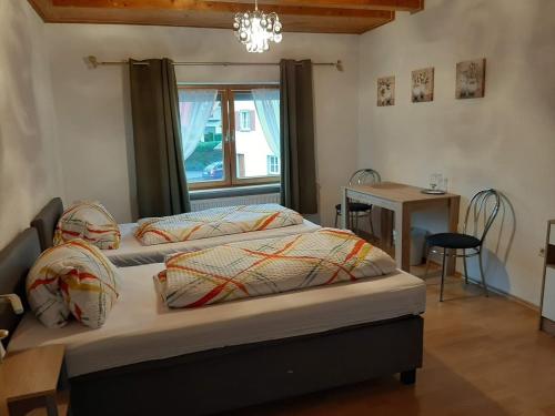 a bedroom with two beds and a table and a window at Gästehaus B & B27 und Pension Waldhorn in Rottweil