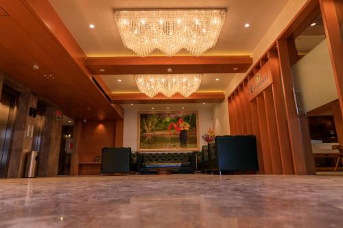 a lobby with a chandelier and chairs in a building at Lords Eco Inn Jamnagar - Apple Gate in Jamnagar