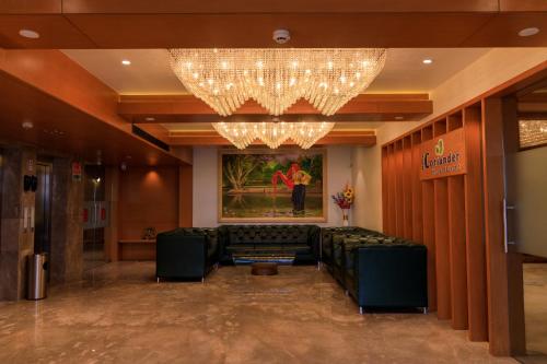 a waiting room with a chandelier and a couch at Lords Eco Inn Jamnagar - Apple Gate in Jamnagar