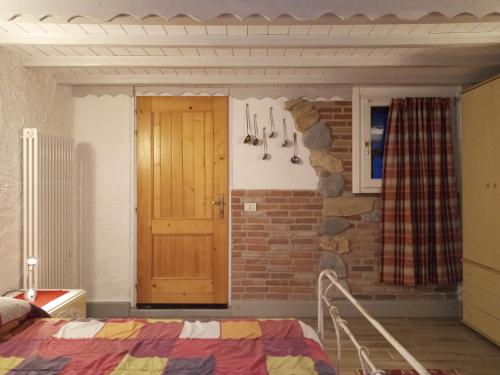 a bedroom with a brick wall and a wooden door at Casa Max in Ledro