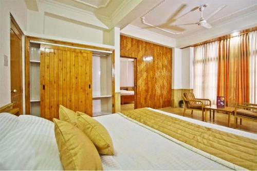 a bedroom with a large bed and a desk at Hotel Snow View Manali in Manāli