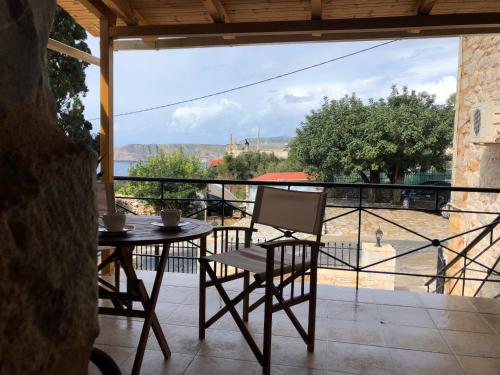 a table and chairs on a balcony with a view at Kamares Stone House 2 in Gerolimenas