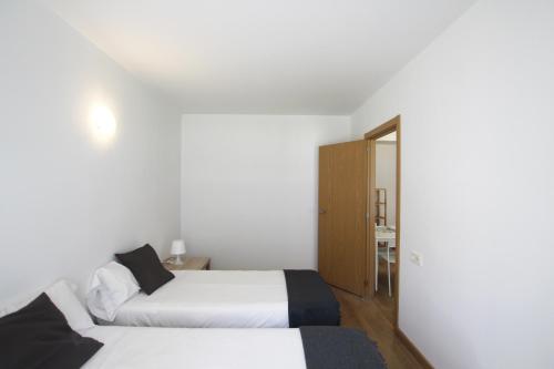 Duas camas num quarto com paredes brancas em Apartamento Labegain 6 em Sestao