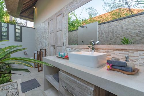 a bathroom with a sink and a mirror at InBalance Resort in Pabean Buleleng
