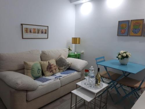 - un salon avec un canapé et une table dans l'établissement La puerta azul en el corazón de Cádiz, à Cadix