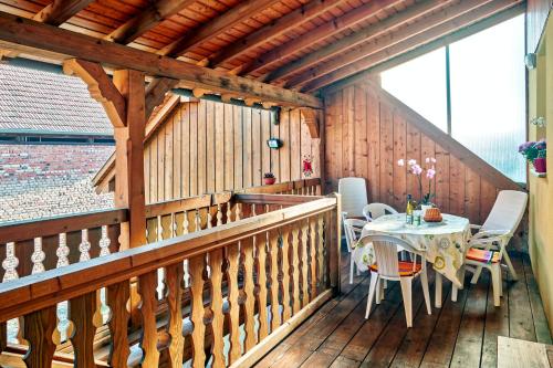 - un balcon en bois avec une table et des chaises dans l'établissement Maison charmante à Stotzheim + jardin, à Stotzheim