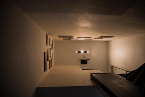 an empty hallway with paintings on the wall and a bench at B&B Pont in Wessem