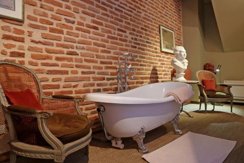 a bath tub in a room with a brick wall at Chambres d'hôtes La Tour Sainte-Cécile in Albi
