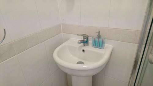 a bathroom with a sink with a toothbrush on it at Room in Guest room - En suite shower room Double room with 1 double deyr in Hayes