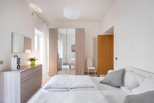a white bedroom with a bed and a mirror at Residenza Ester in Riva del Garda