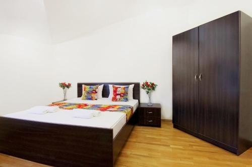 a bedroom with a large bed and a wooden cabinet at 2 Bedroom Apartment on Chaikovski street in Yerevan