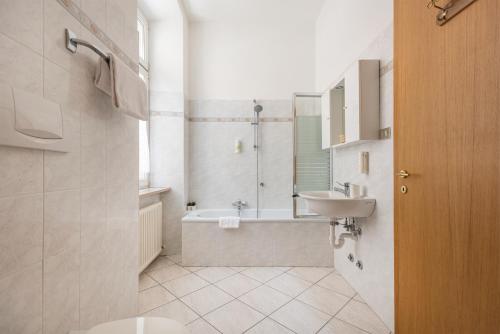 a bathroom with a tub and a sink and a toilet at Residenza Ester in Riva del Garda