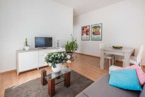 a living room with a couch and a tv and a table at Residenza Ester in Riva del Garda