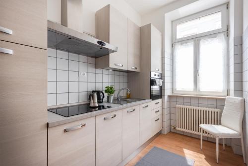 a kitchen with white cabinets and a window at Residenza Ester in Riva del Garda