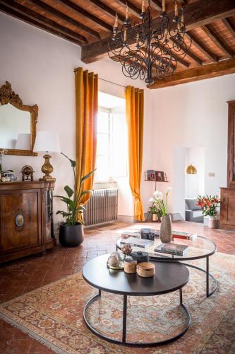 a living room with a table and a large window at Il Giardino del Cardinale - Deb'S Monticchiello in Monticchiello