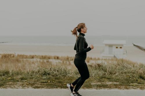a woman riding a skateboard down a road at Hotel de Blanke Top in Cadzand-Bad