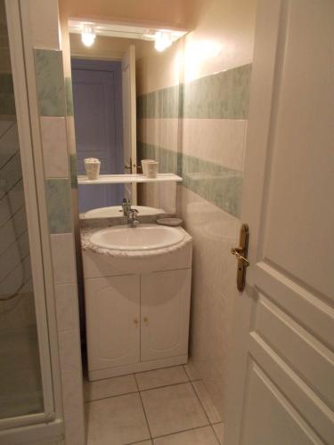 une salle de bain blanche avec un lavabo et un miroir dans l'établissement La Bourgade, à Estréelles
