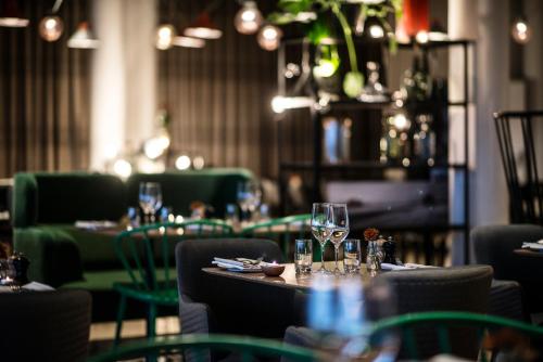 a restaurant with tables and chairs with wine glasses at Frösö Park Hotel in Östersund
