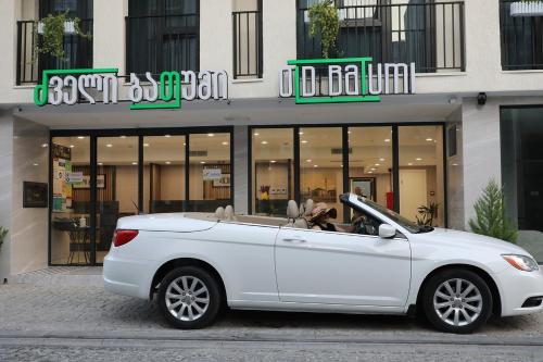 a white car parked in front of a store at Old Batumi Hotel in Batumi
