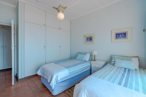 two beds in a room with white walls at 2C Edward Place in Ballito