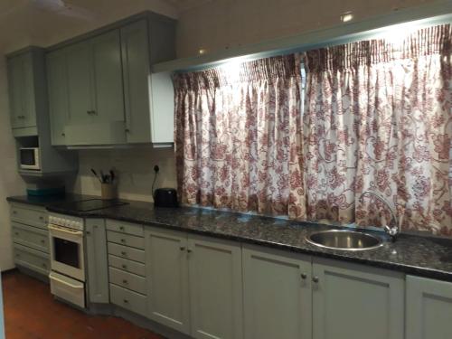 a kitchen with a sink and a shower curtain at 2C Edward Place in Ballito