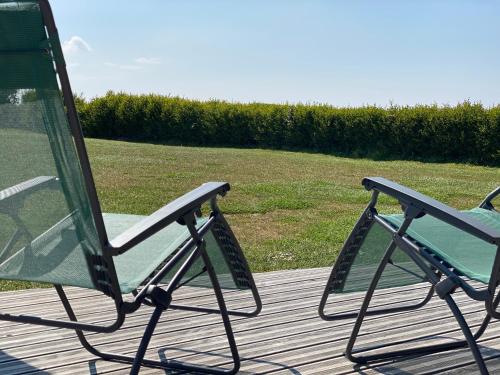 two chairs sitting on top of a wooden deck at Bellevues-Sur-Mer, à 100 m de la plage in Trévou-Tréguignec
