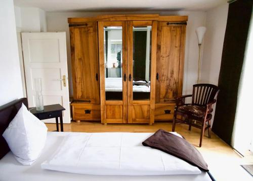 a bedroom with a bed and a chair and a door at Ferienwohnung Riesenblick in Frasdorf