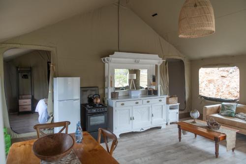 a kitchen with a refrigerator and a table in a room at Grysbokkloof Private Nature reserve luxury Glamping 6km from Montagu in Montagu