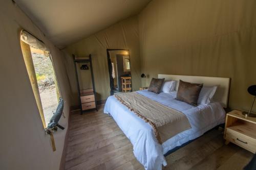 una camera con un grande letto in una tenda di Grysbokkloof Private Nature reserve luxury Glamping 6km from Montagu a Montagu