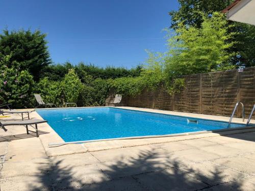 - une piscine dans une cour à côté d'une clôture dans l'établissement La Maison des Brandes, à Eynesse