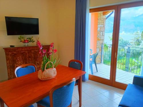 a dining room with a table with chairs and a television at Hotel Villa Isabella in Brenzone sul Garda