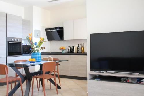 a kitchen with a table and a large television at Casa Mari in Villasimius