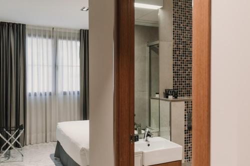 a bathroom with a sink and a mirror at Citizentral Juristas in Valencia