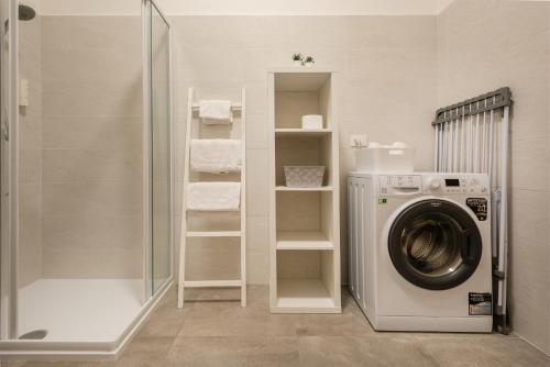 a bathroom with a washing machine and a shower at Residenza Ester in Riva del Garda