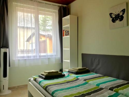 Un dormitorio con una cama con una mariposa. en Tutijó Házikó, en Balatonfenyves
