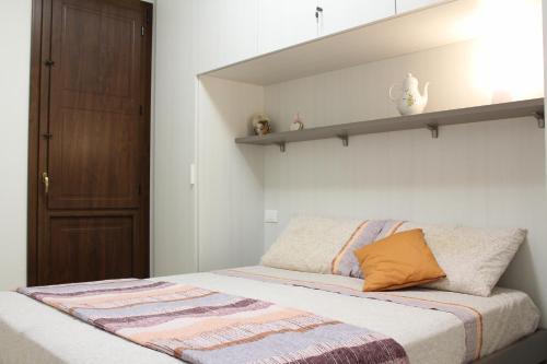a bedroom with a bed with a shelf on the wall at Casa Mari in Villasimius