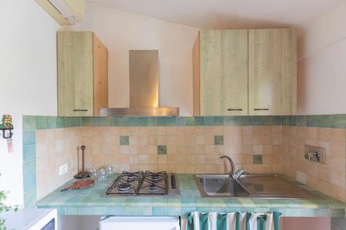 una cucina con lavandino e piano cottura forno superiore di Casa Germana by HelloElba a Portoferraio