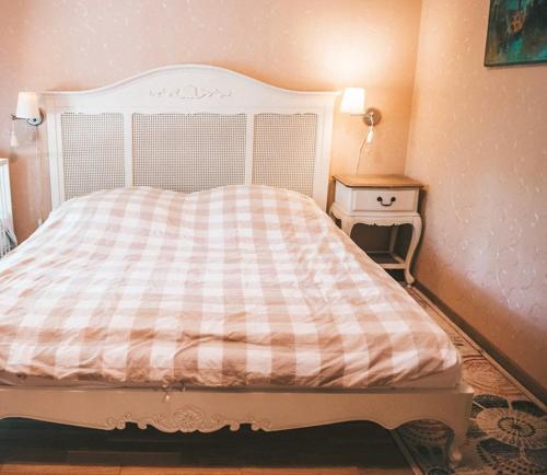 a bedroom with a bed with a checkered blanket at Apartamentai Juodkranteje in Juodkrantė