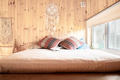1 dormitorio con cama con almohadas y lámpara de araña en Rouna Family Home en Ainja