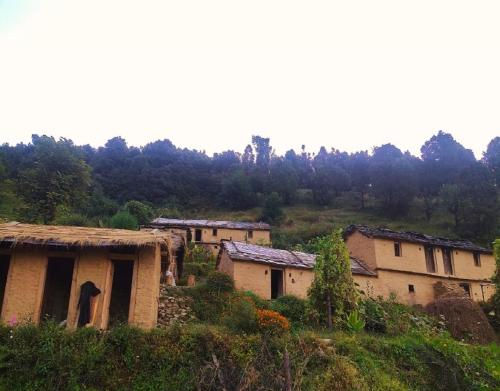 a group of houses on a hill with trees at Bursol Homestay by StayApart in Chamoli