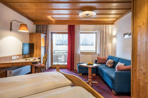 Habitación de hotel con cama y sofá en Hotel am Haslinger Hof en Kirchham
