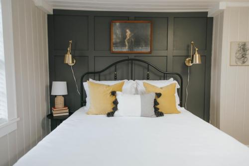 a bedroom with a large bed with yellow pillows at The Woodlawn Tudor in Hot Springs