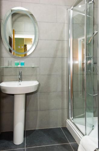 a bathroom with a sink and a shower at Caring Hotel in London