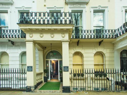 a building with a balcony on top of it at Caring Hotel in London