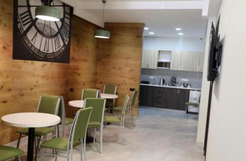 a dining room with tables and chairs and a clock on the wall at Loft Host Yerevan in Yerevan