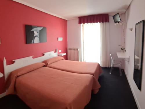 ein rotes Schlafzimmer mit 2 Betten und einem Fenster in der Unterkunft HOTELSANMARTIN in Frómista